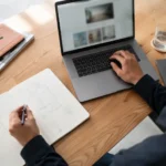 Designer using arrow symbols while working on a laptop
