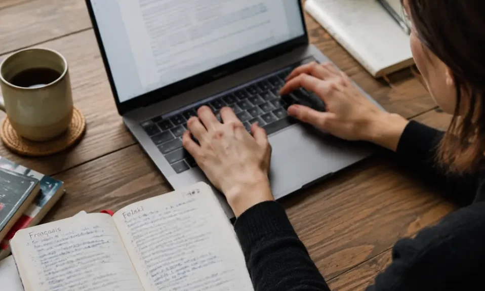 Writer typing E with accent characters on a laptop